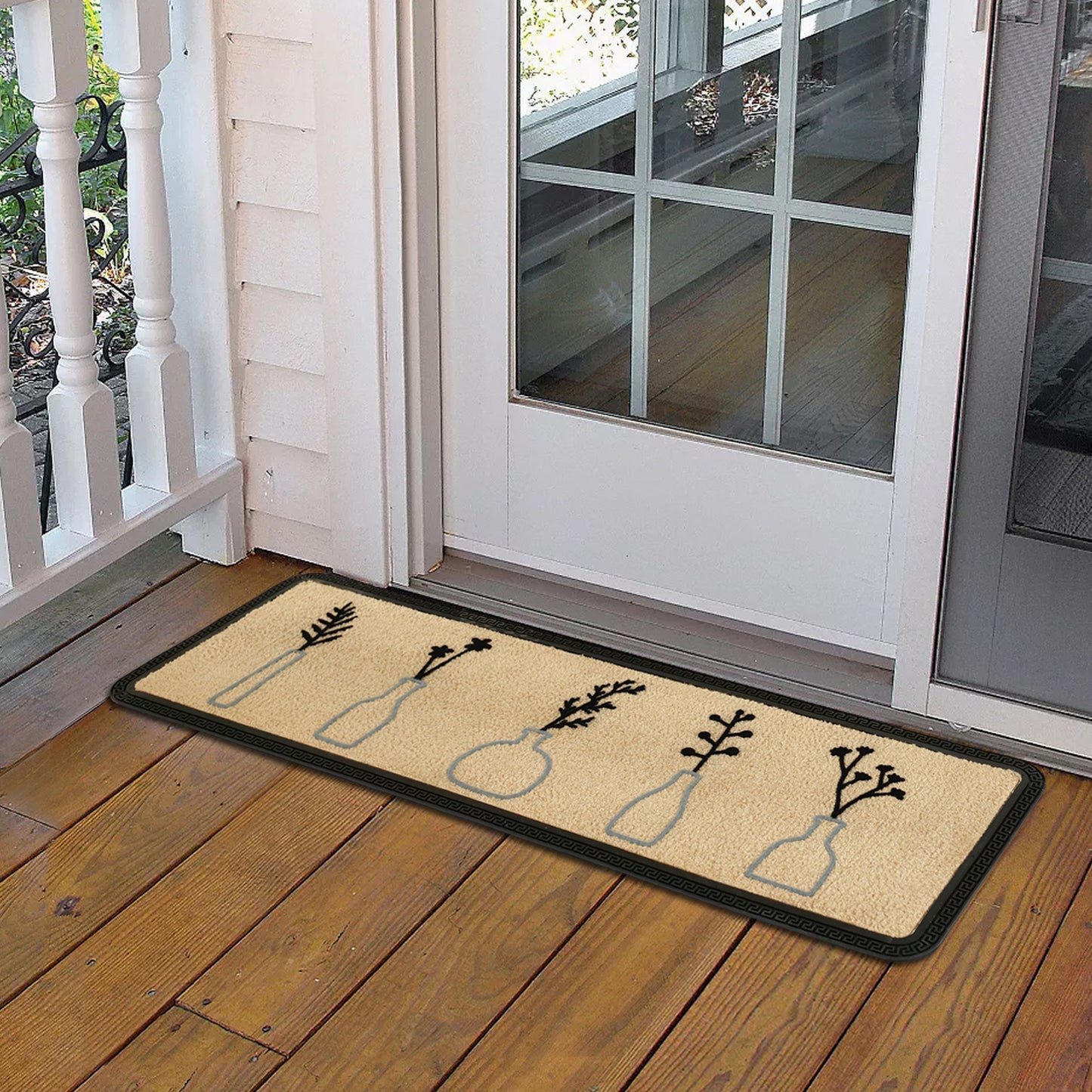 A beige rectangular doormat with a floral pattern, featuring a series of potted plant designs, placed on a wooden floor mat in front of a door.
