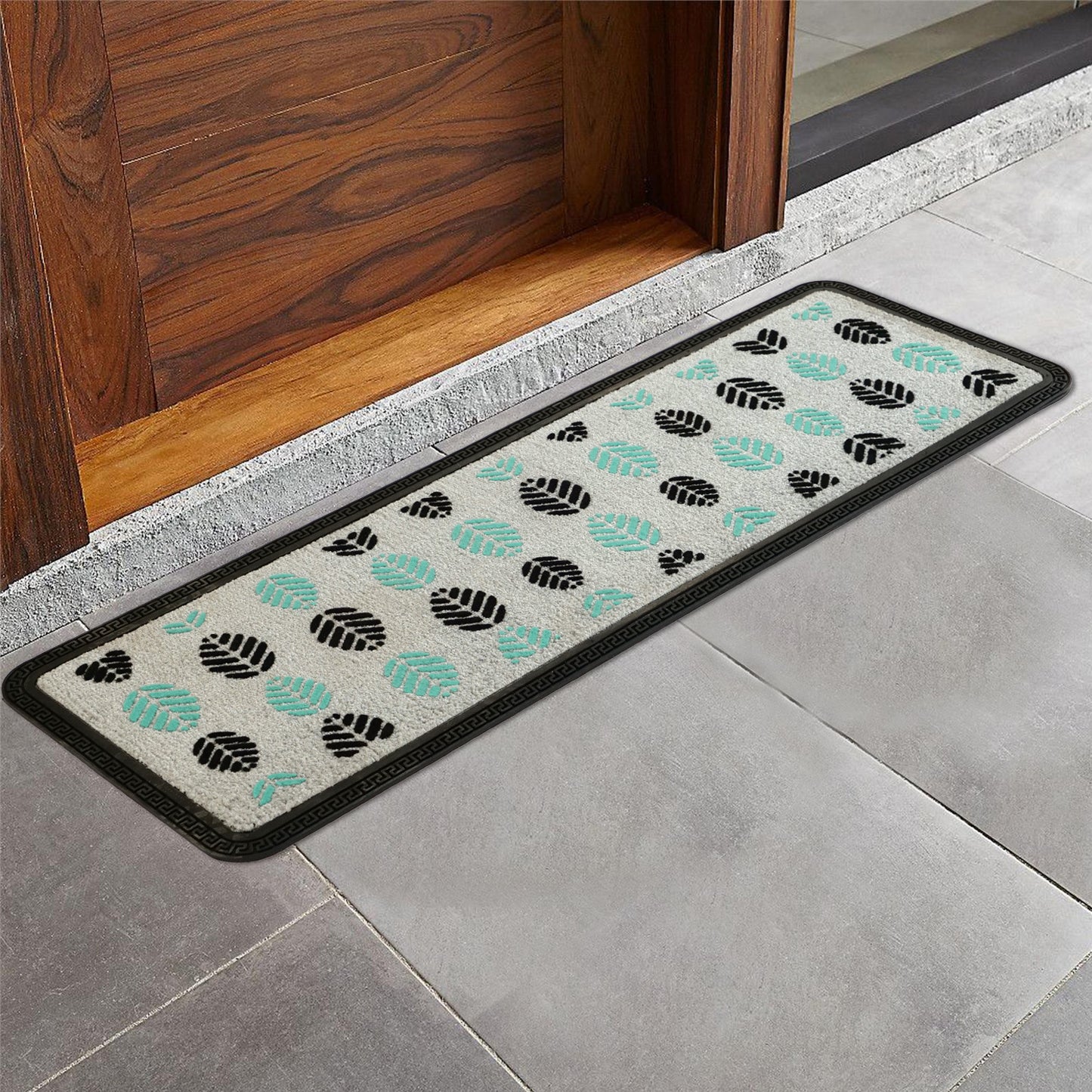 A grey rectangular long floor mat with a leaf pattern is placed on a tiled floor.