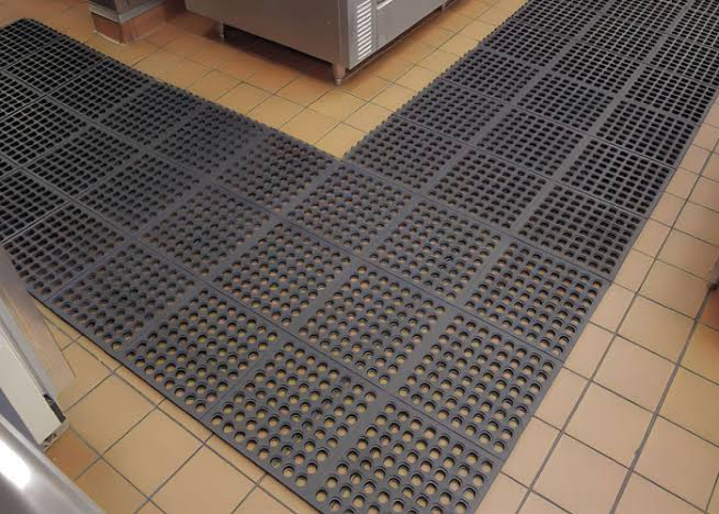 Grid-patterned interlocking rubber mat on tiled floor