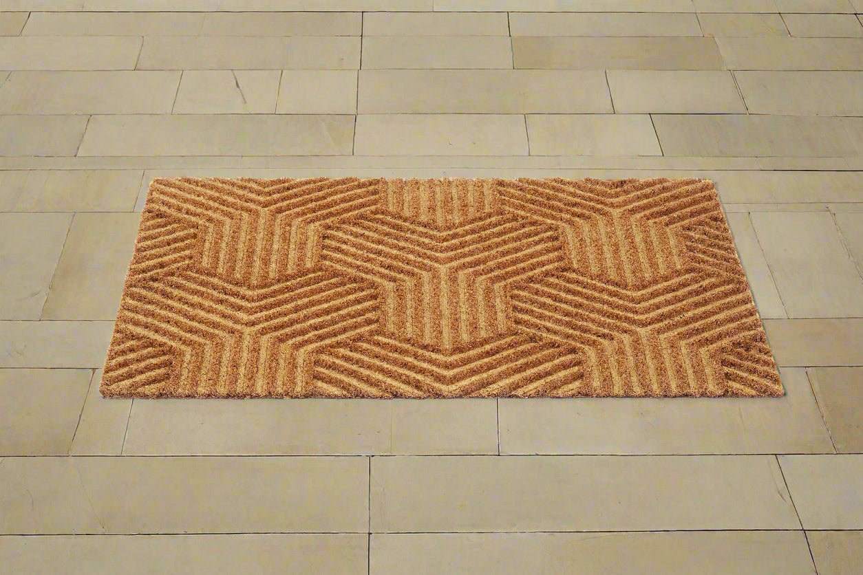 A beige, rectangular Mat with an impression design placed on a tiled floor.