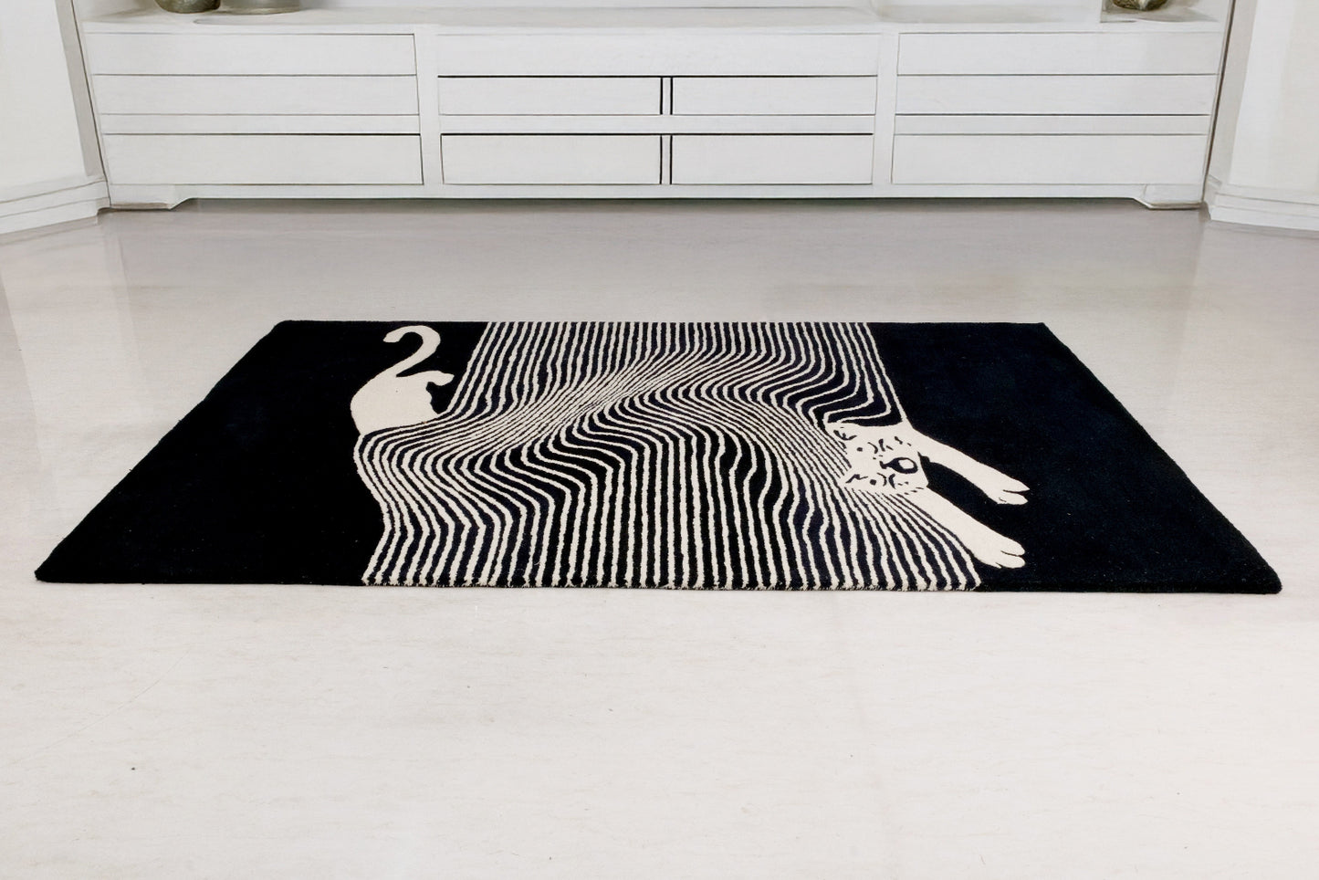 Black rug with white abstract design on a white floor