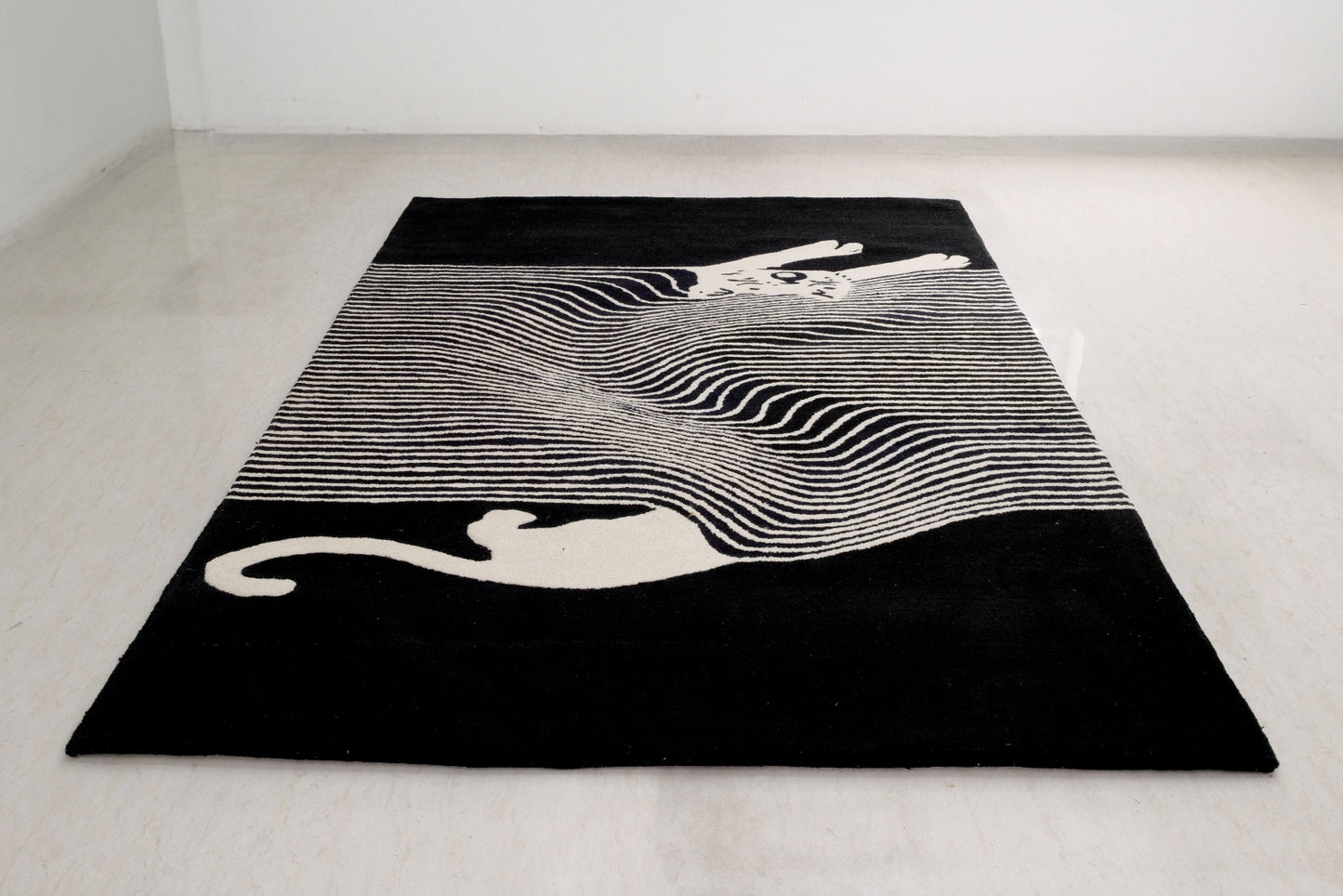 Black and white patterned rug with abstract design on a light gray floor.