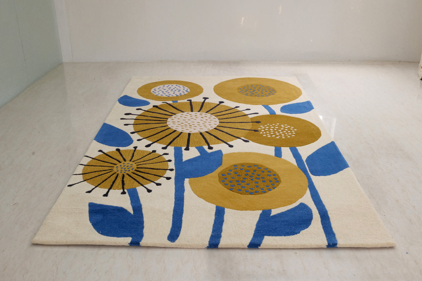 A hand-tufted bamboo silk rug with a modern floral design in yellow and blue colors on a white background, displayed on the floor.