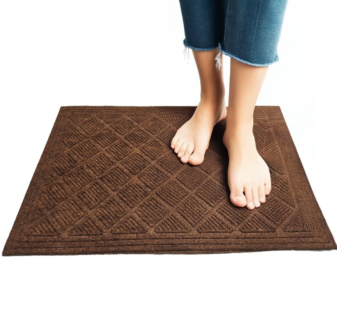 A person standing on a brown rectangular anti-slip bath mat with a textured diamond pattern, placed on a white background.