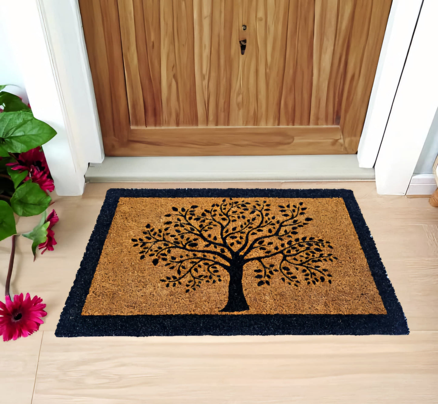 Rectangular natural coir doormat with a printed tree design in the centre, placed on a wooden door's threshold.