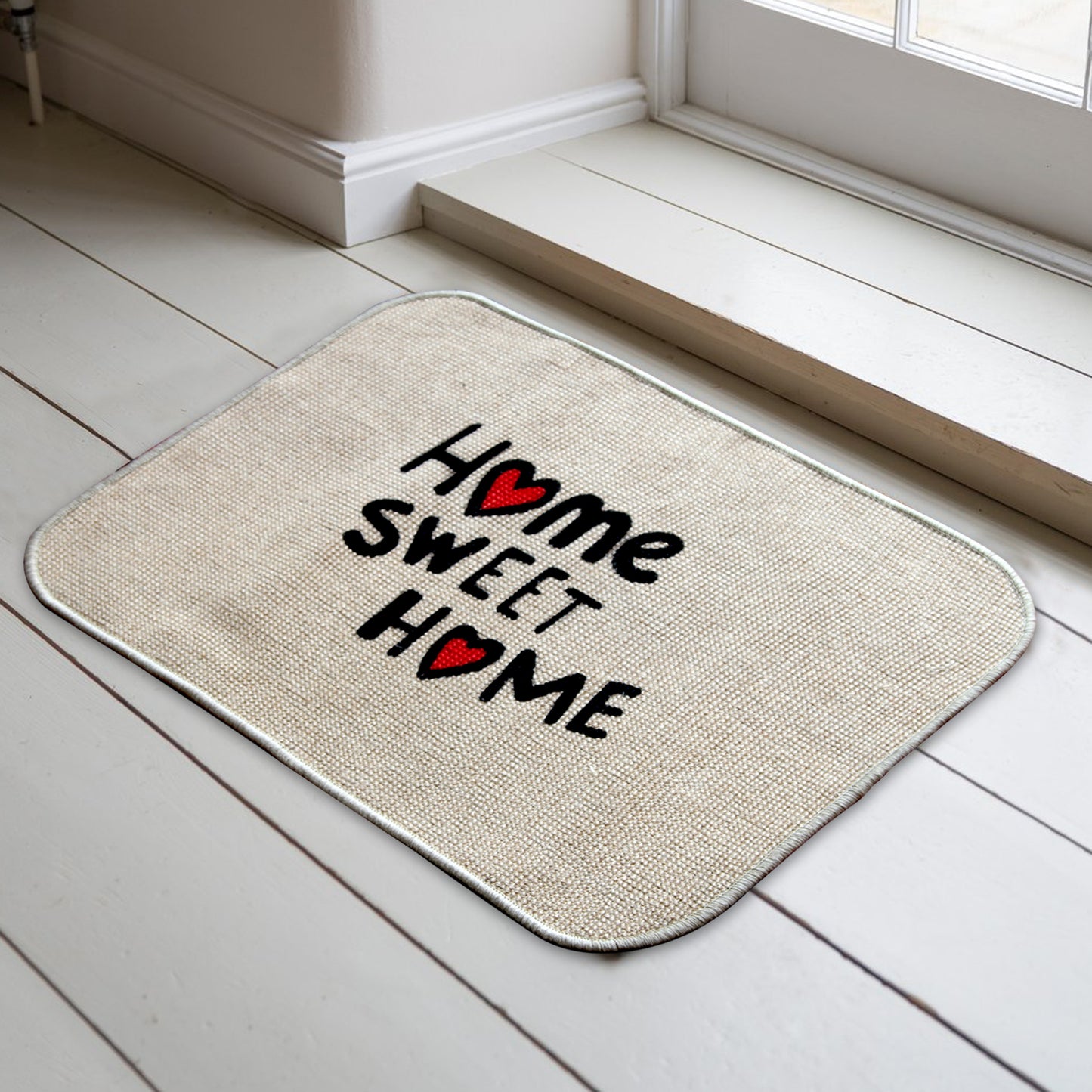 A beige jute printed micro boucle door mat with the text 'HOME SWEET HOME' and a red heart symbol, placed on a light wooden floor.