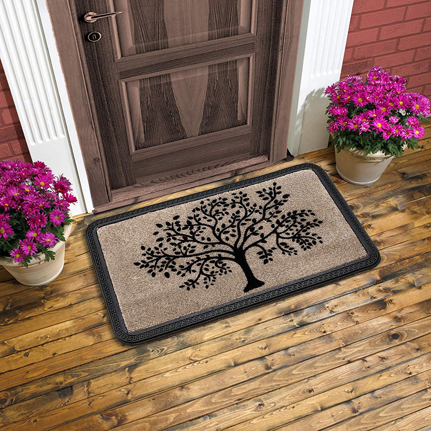 A beige colored rectangular door mat with a tree pattern, placed on a wooden floor with two potted plants flanking the sides.
