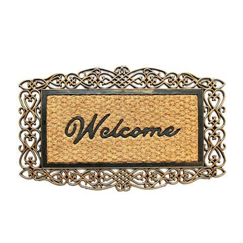 A rectangular coir doormat with a metallic finish and the word 'Welcome' printed in bold black letters, enclosed in a decorative border with a leaf-like design.