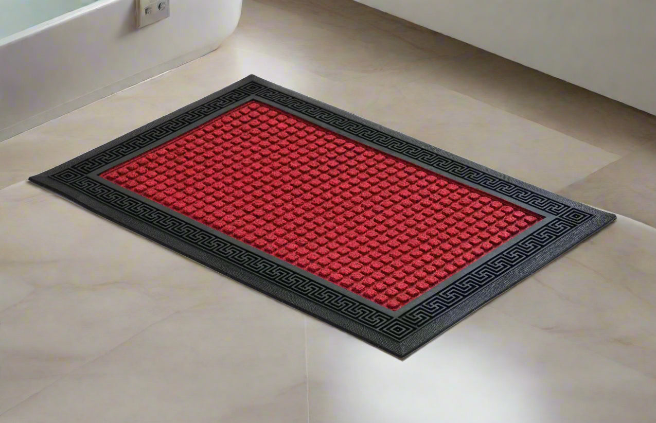 A red and black OnlyMat-branded bath mat placed on a tiled floor, featuring an anti-slip design with a geometric pattern.