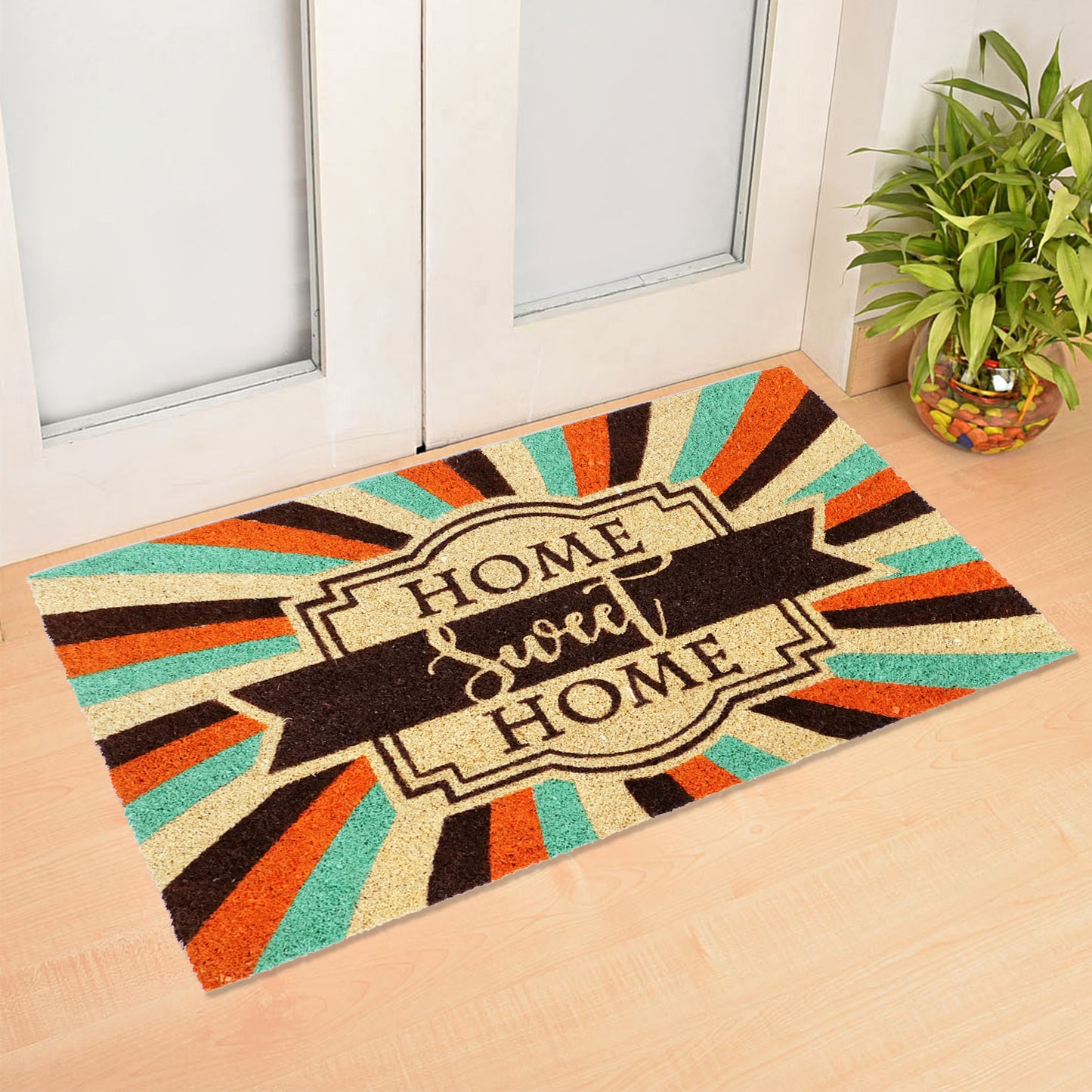 Rectangular natural coir door mat with a colourful geometric pattern and the text 'HOME SWEET HOME' in the centre, placed on a doorstep.