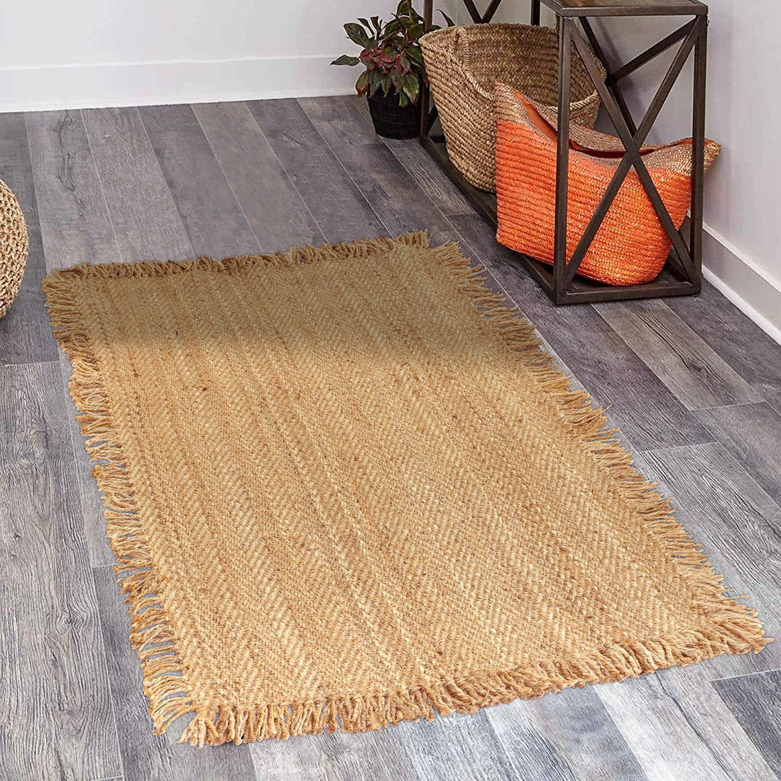 
                      
                        A beige jute rug with a high pile is placed on a wooden floor, complementing the interior decor of a room with a plant and a metal sculpture.
                      
                    