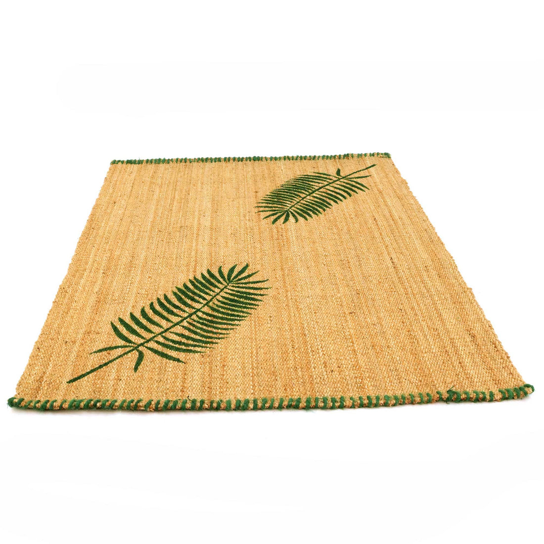 Woven jute mat with green leaf patterns on a white background