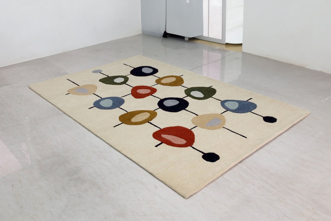 A hand-tufted Bamboo Silk rug with a modern design in beige, brown, grey, and multicoloured geometric patterns on a light background.