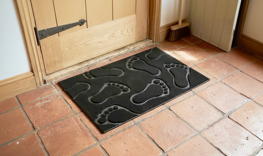 
                      
                        Doormat with footprints on a tiled floor in front of a wooden door.
                      
                    