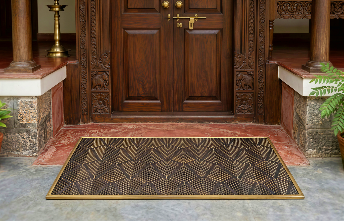 Decorative doormat in front of a wooden door with intricate carvings.