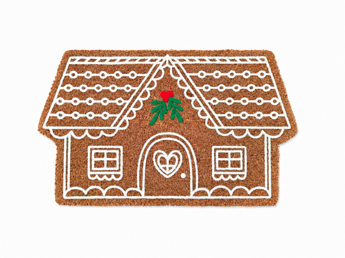 
                      
                        Doormat shaped like a gingerbread house with a red holly leaf on a white background
                      
                    