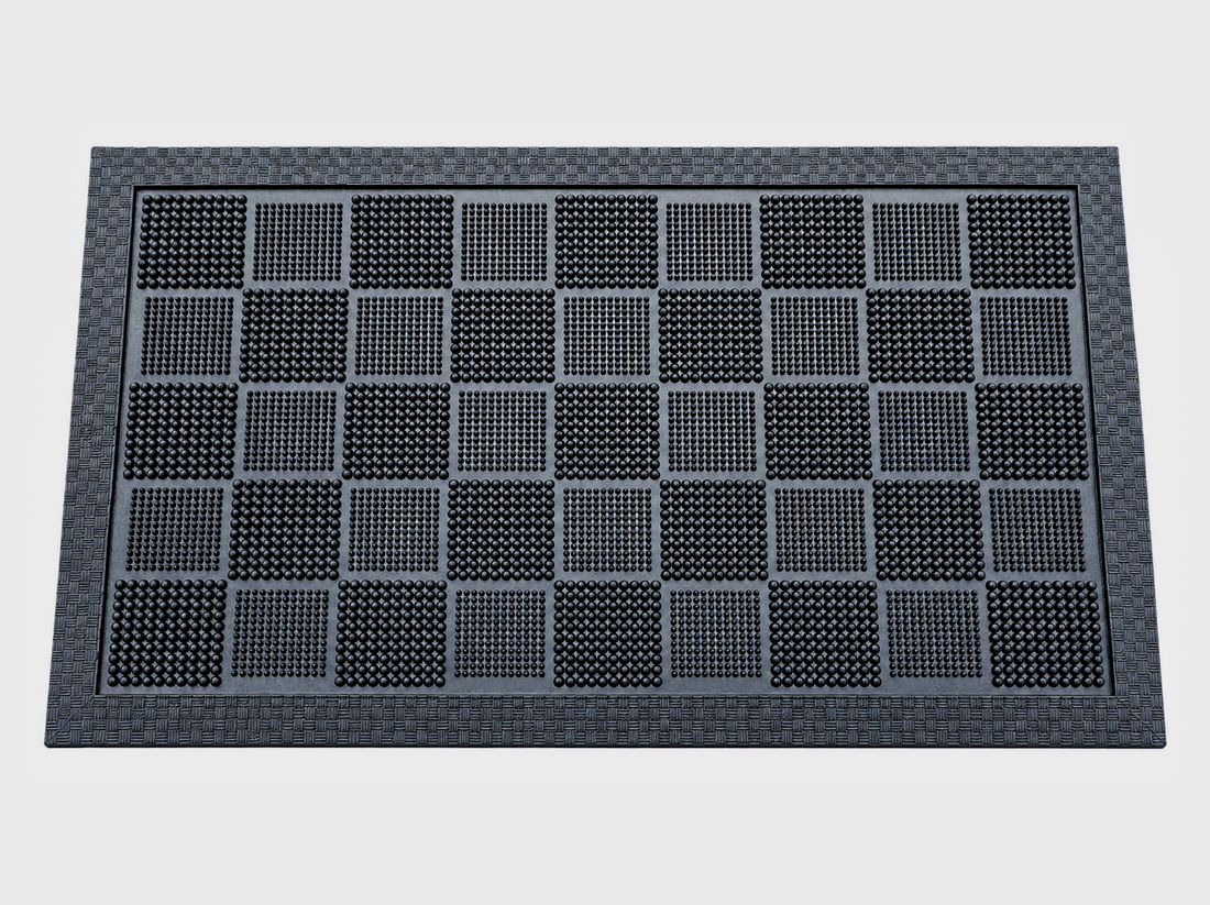 
                      
                        A rectangular black rubber doormat with a textured border and a grid pattern of raised square panels, shown from a top-down perspective on a light gray background.
                      
                    