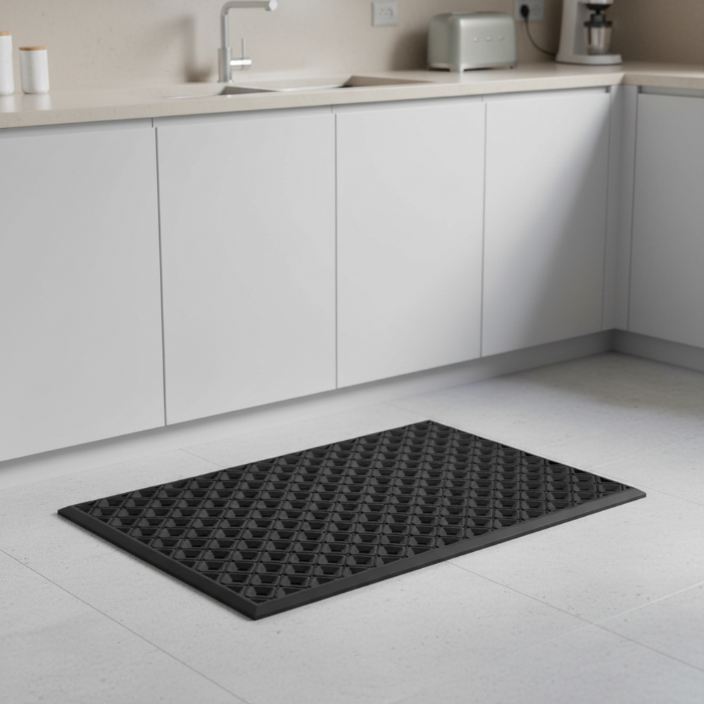 Black mat on a kitchen floor with white cabinets and appliances in the background