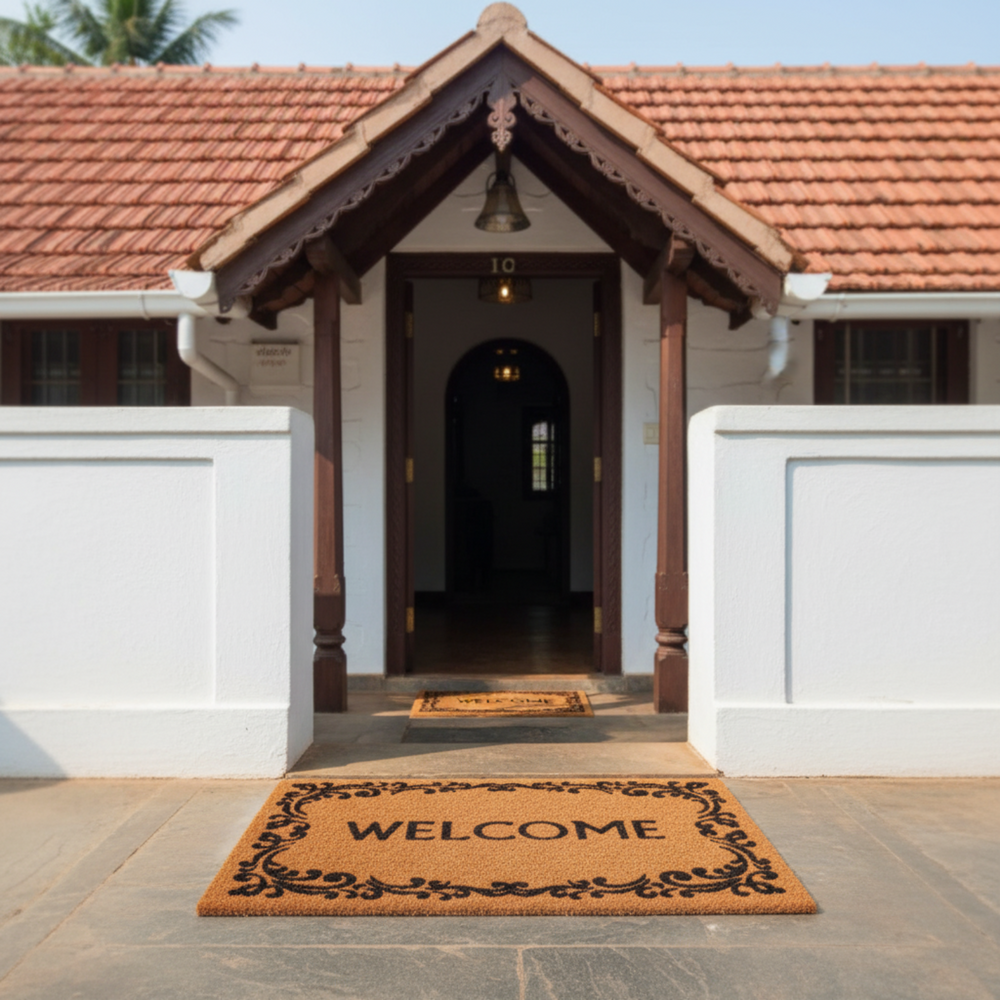 Traditional house entrance with a 'Welcome' coir mat on a wooden floor.