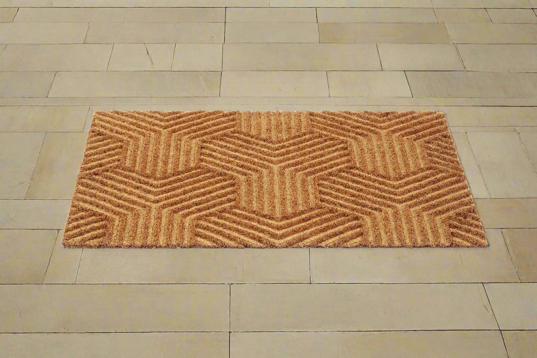 A beige, rectangular Mat with an impression design placed on a tiled floor.