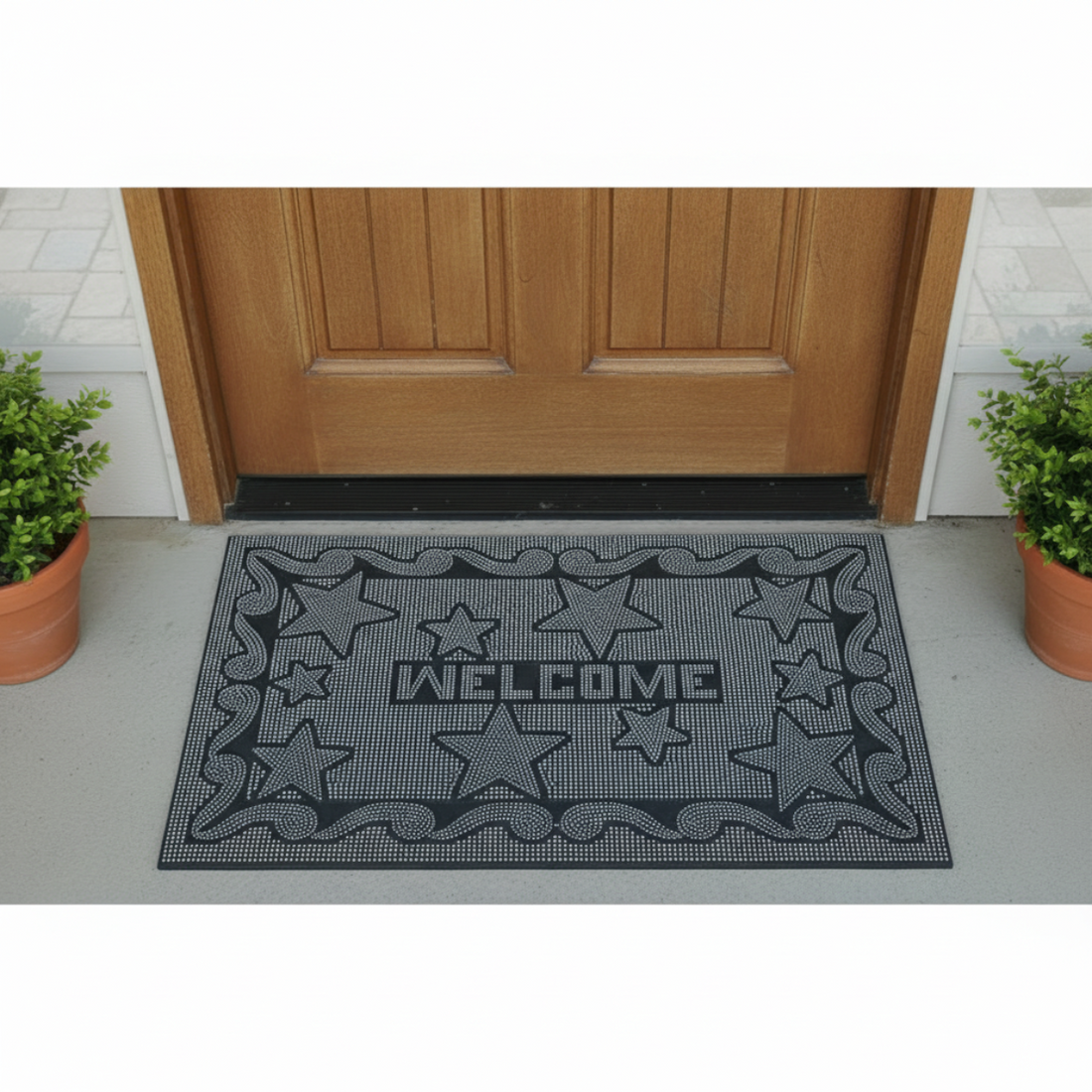 Black doormat with star pattern and 'Welcome' text on a gray floor in front of a wooden door.