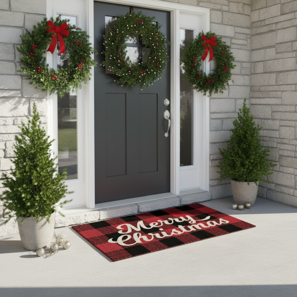 Front door with wreaths and a 'Merry Christmas' mat on a stone building exterior.