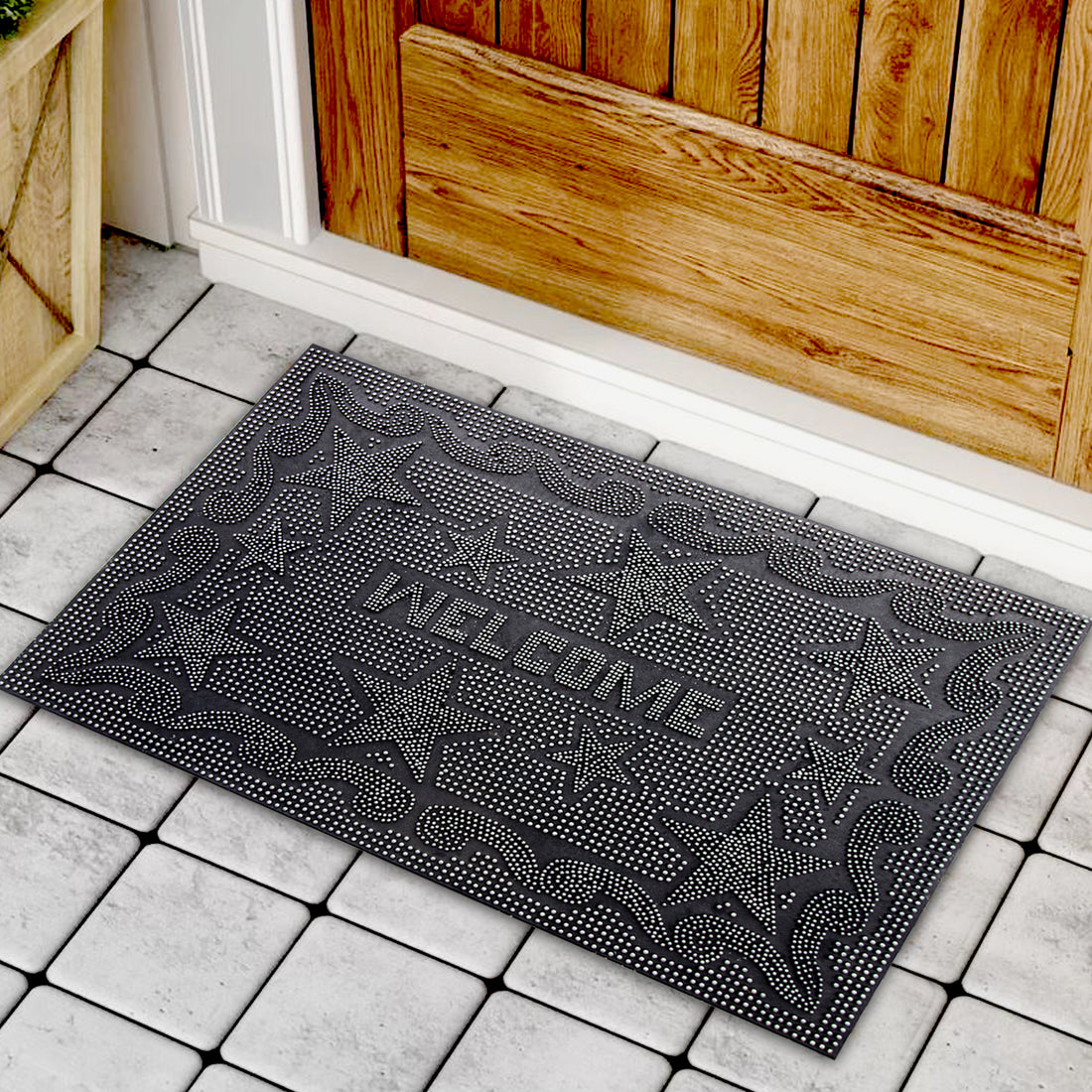 
                      
                        A black rectangular doormat with a geometric pattern of stars and diamonds, featuring the word 'WELCOME' in bold letters, placed on a tiled floor in front of a wooden door.
                      
                    