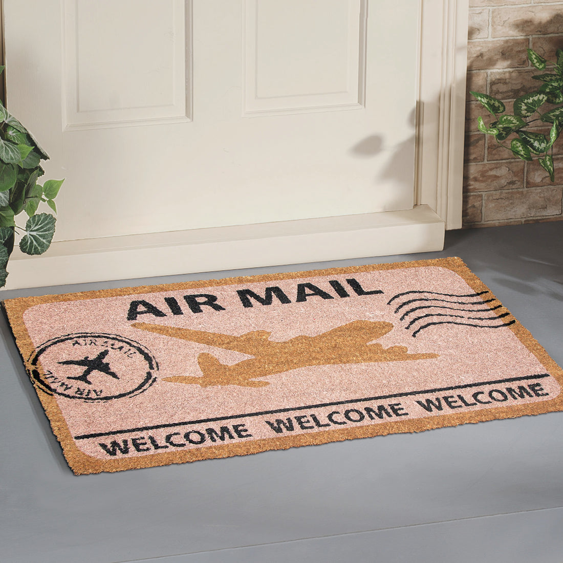 A rectangular natural coir doormat with 'AIR MAIL' and 'WELCOME' printed in black, along with an illustration of an aeroplane.