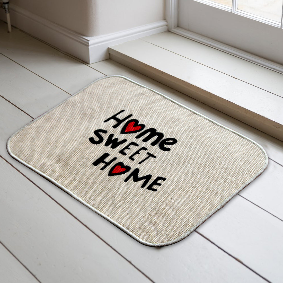 
                      
                        A beige jute printed micro boucle door mat with the text 'HOME SWEET HOME' and a red heart symbol, placed on a light wooden floor.
                      
                    