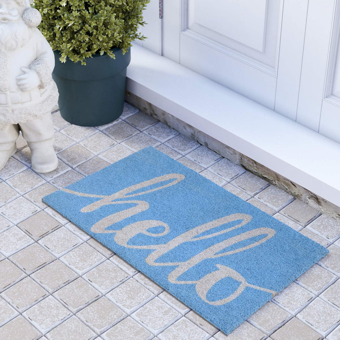 A light blue entrance mat with the word 'Hello' printed in white, placed on a tiled floor in front of a door, with a small potted plant to the left and a decorative figure to the right.