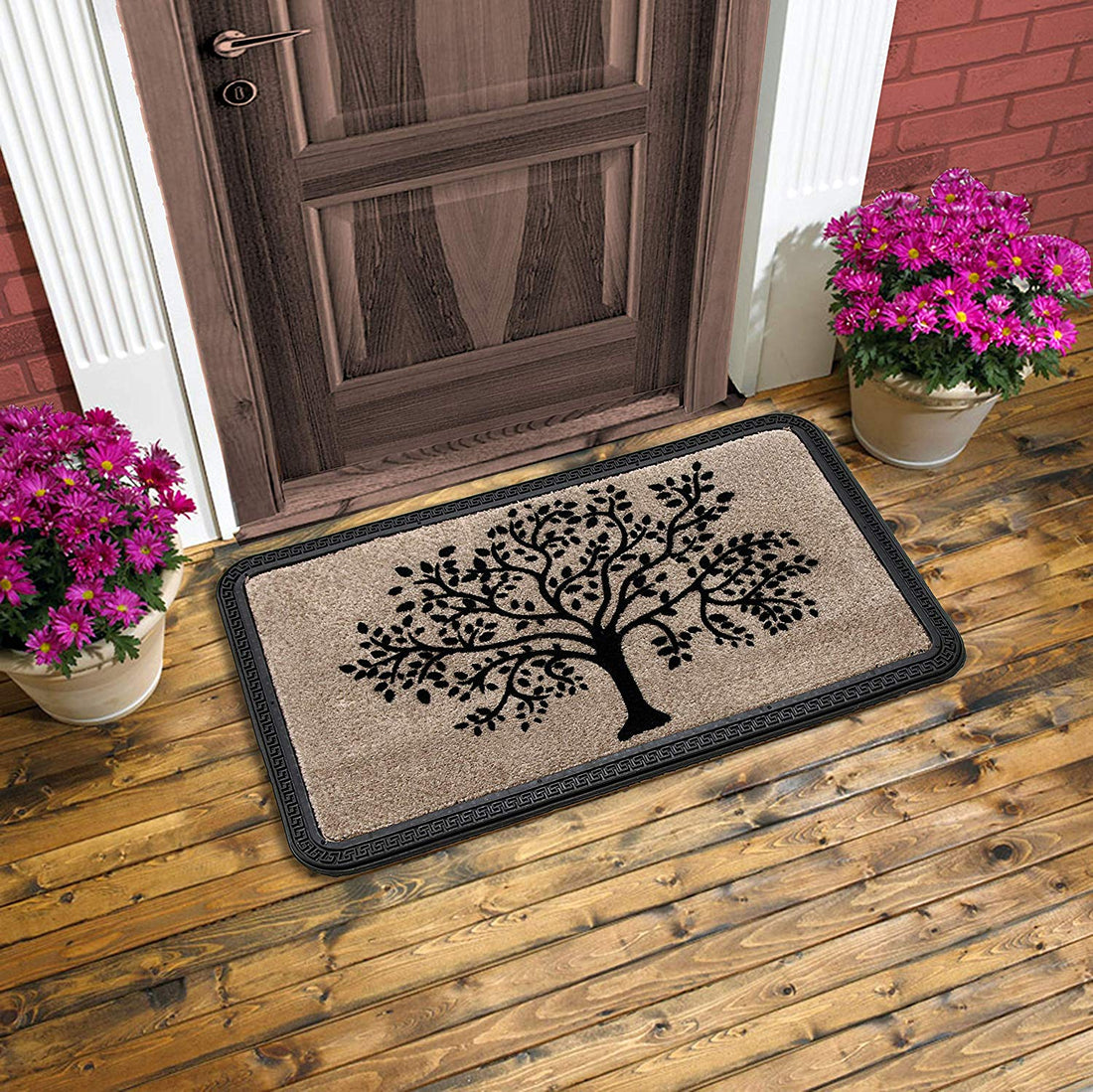 A beige colored rectangular door mat with a tree pattern, placed on a wooden floor with two potted plants flanking the sides.