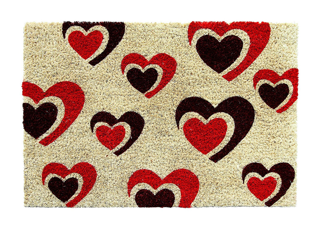 A rectangular coir floor mat with a love heart pattern in red and black colours on a beige background.