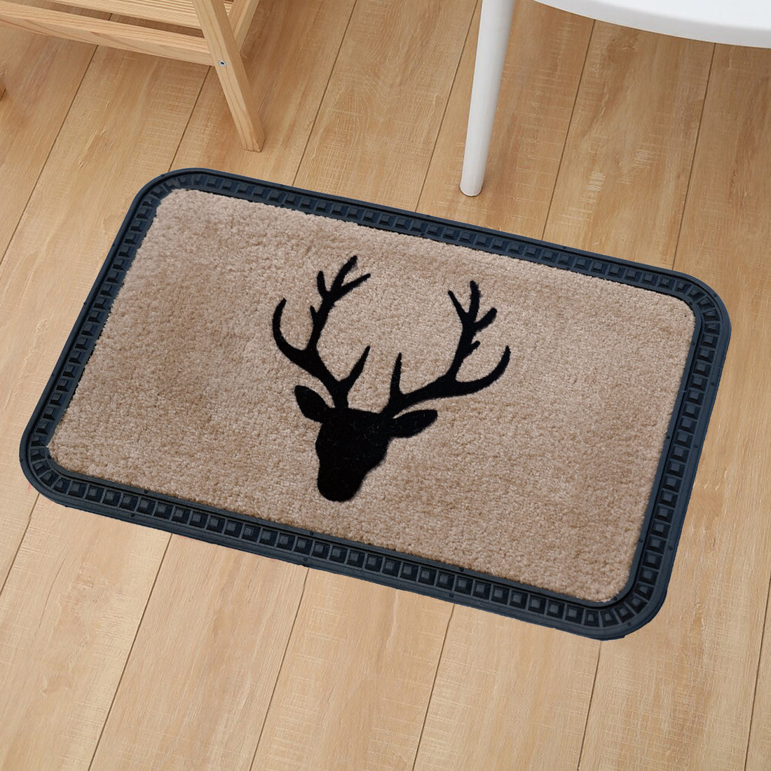 A rectangular beige doormat with a black reindeer design is placed on a wooden floor with a black border.