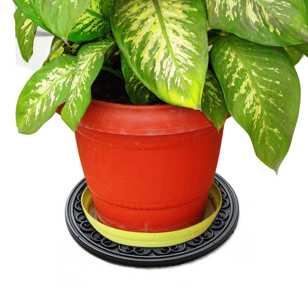 A round, heavy-duty black rubber mat is placed under a red flower pot with a green and yellow leafy plant.