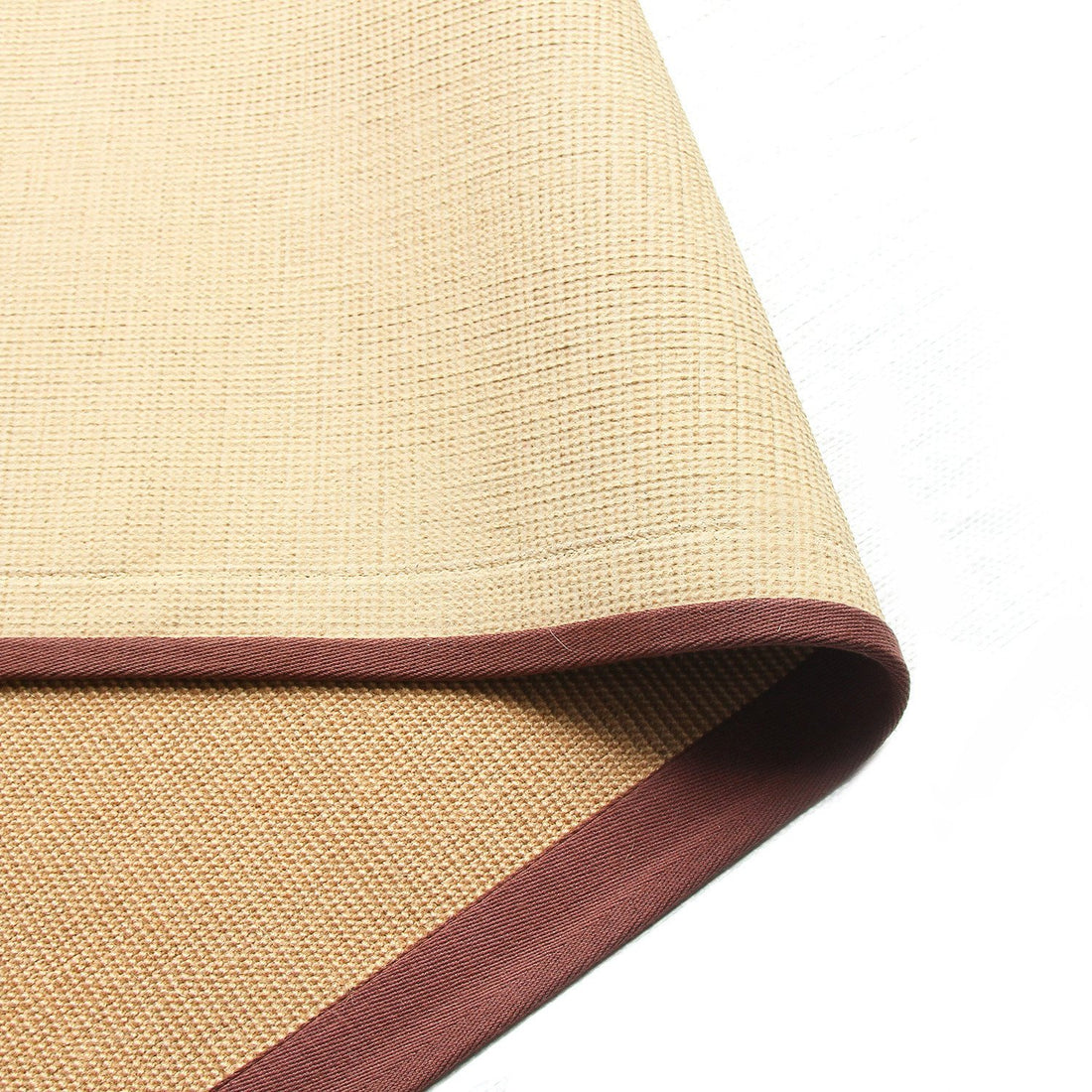 
                      
                        A beige jute yoga mat with a brown cotton border and a small section of the latex backing visible.
                      
                    