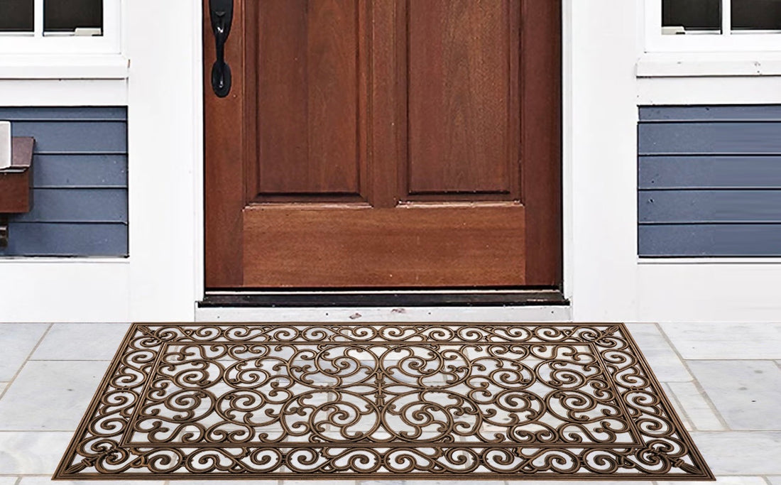 A copper finish rubber iron grill mat placed on the doorstep of a home, featuring intricate geometric patterns.