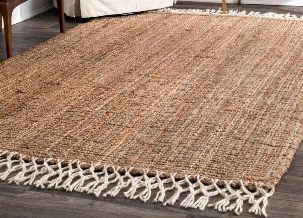 Textured brown rug with white fringe on a wooden floor