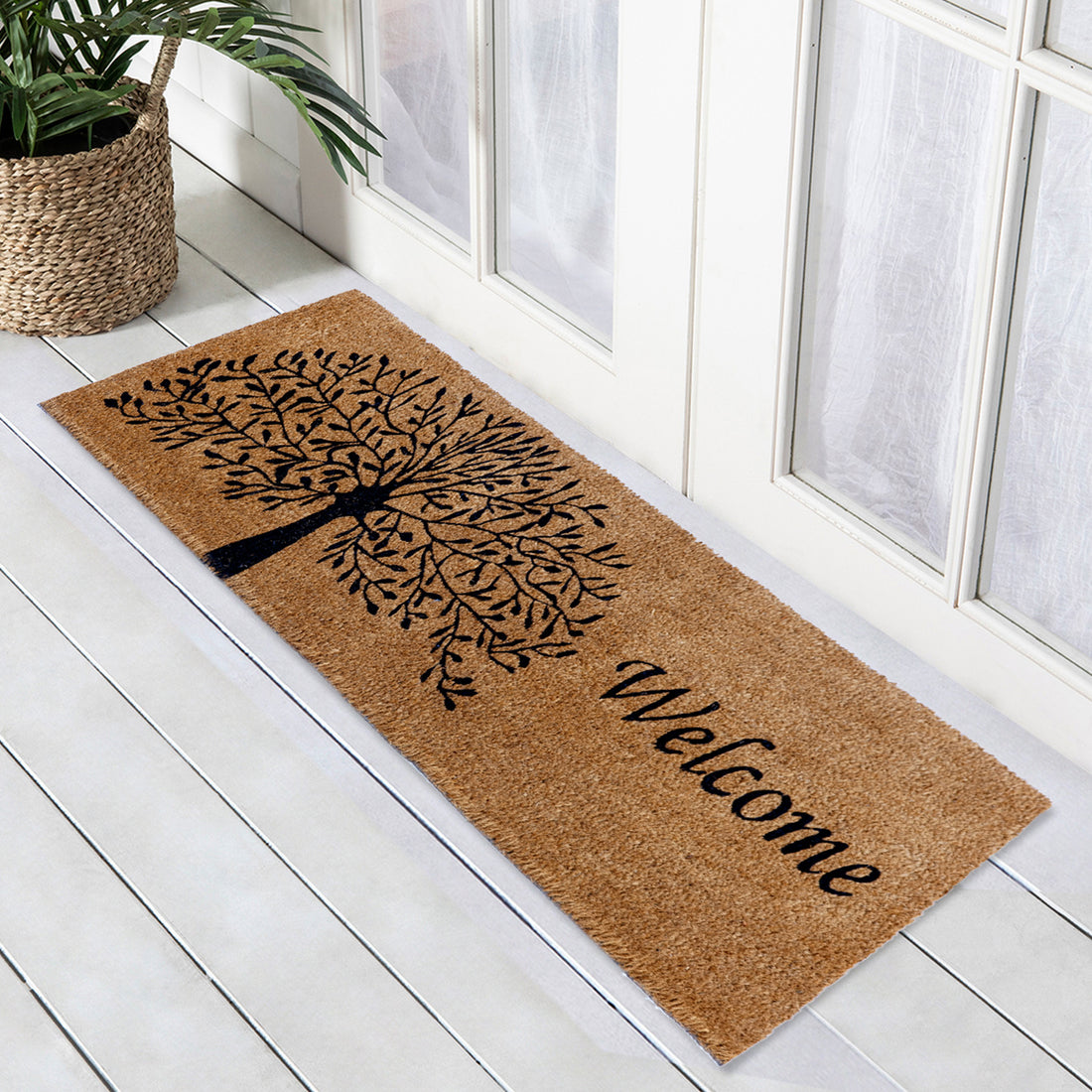 
                      
                        Oblong natural coir entrance door mat with a printed tree of life design and the word 'Welcome' on it, placed on a white door threshold.
                      
                    