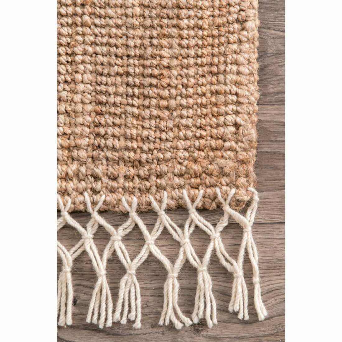 Textured woven rug with white fringe on a wooden floor