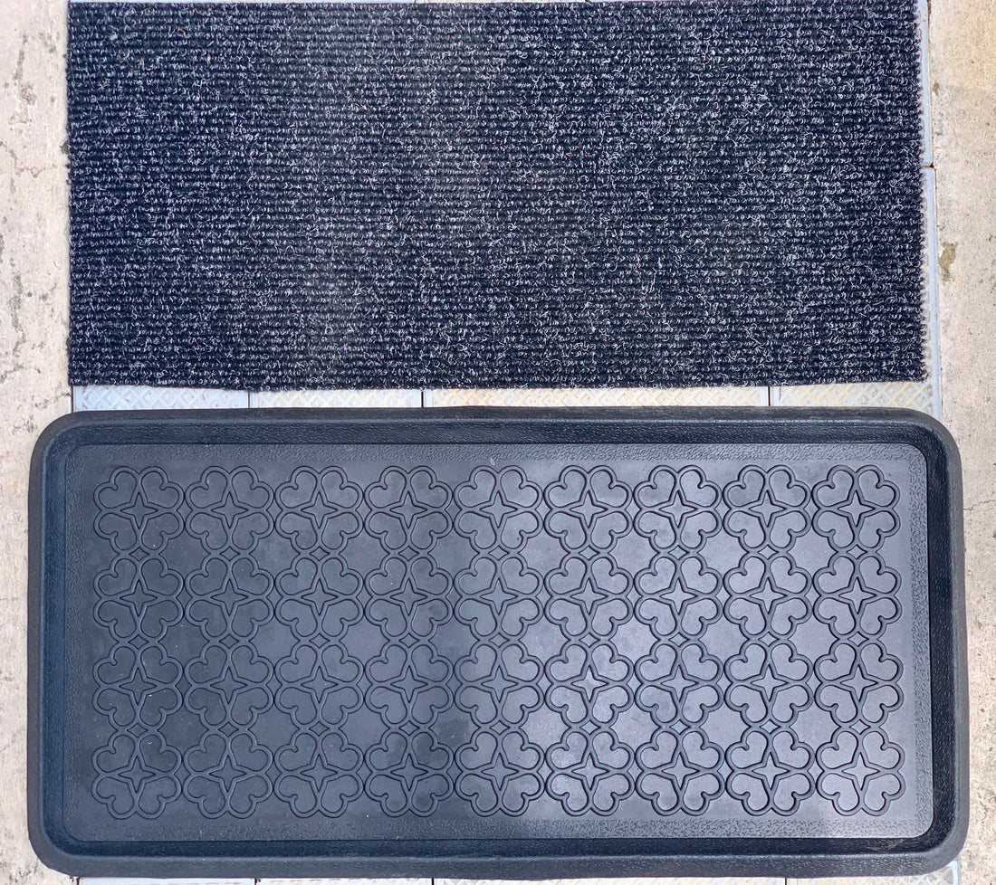 A black rubber tray mat with a geometric pattern design, placed on a surface with liquid absorbed into it, presumably for sanitising or disinfecting purposes.