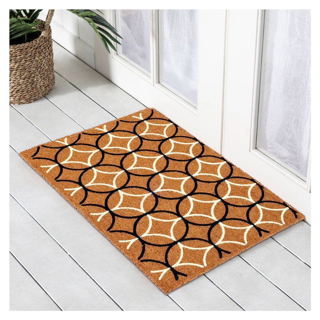 A rectangular coir doormat with a geometric circle pattern in brown and white colors, placed on a light wooden floor.