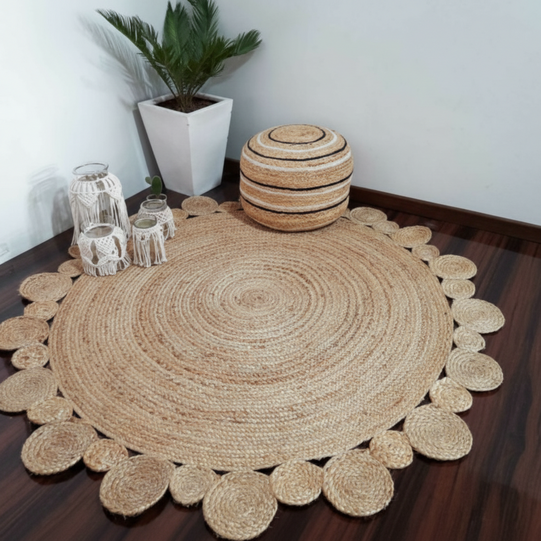 Round woven jute rug on a wooden floor with decorative items and a plant.