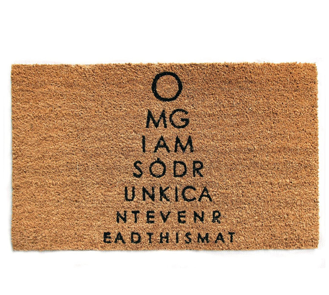 Rectangular natural coir door mat with the humorous printed design 'OMG I am so drunk I can't even read this mat' in black font, placed on a white background.