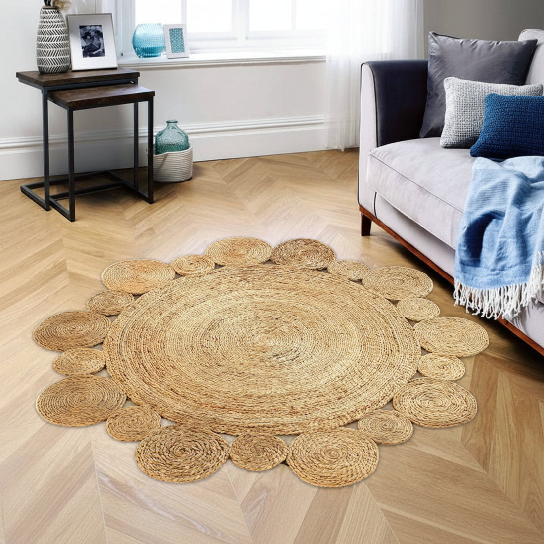 Round woven jute rug on a wooden floor with a sofa and side table in the background