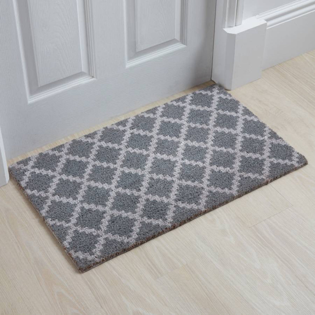 
                      
                        A rectangular natural printed coir floor mat with a geometric diamond pattern, placed on a doorstep.
                      
                    