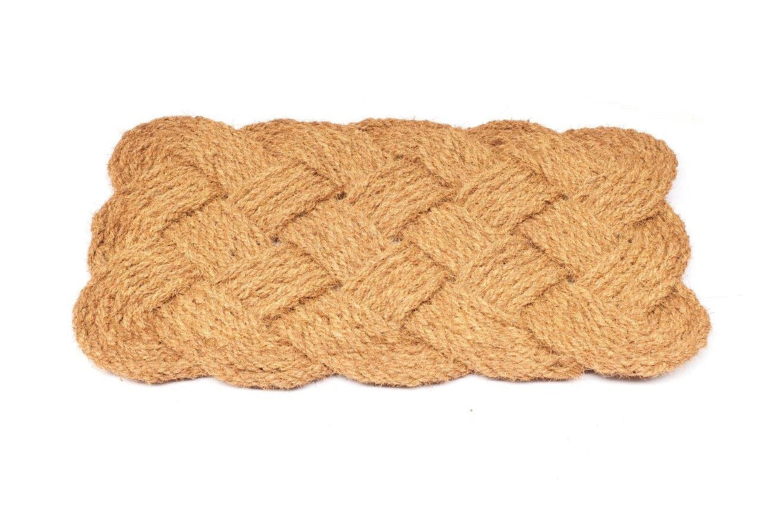 Woven coir rope doormat with braided pattern on a white background