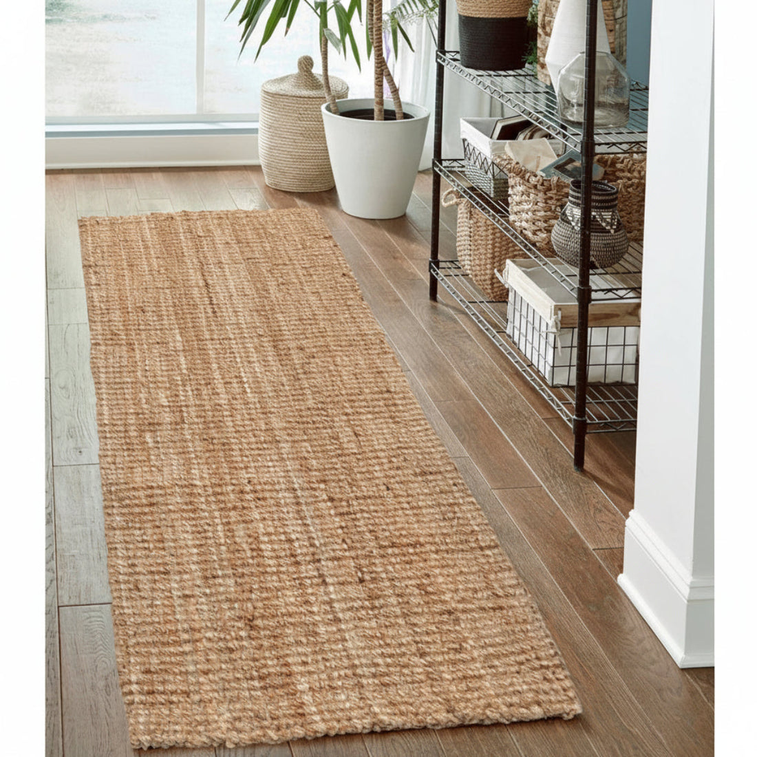 
                      
                        Woven jute runner rug on a wooden floor with a shelf and plants in the background
                      
                    