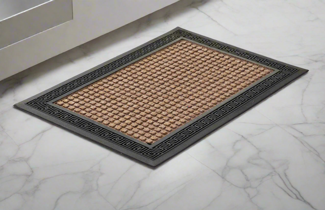 A beige polypropylene bathroom door mat with an anti-slip base, placed on a marble floor.